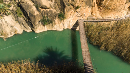 aerial view of a suspension bridge over a river in a valleyの写真素材