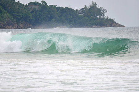 A powerful crystal green ocean wave on a beautiful beach, Phuket, Thailand.の写真素材