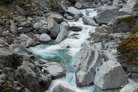 A beautiful view of turquoise water stream, consists of silt particles or glacial flour, in creek which caused by glacier erosion at the top of mountain along the journey in New Zealand.の写真素材