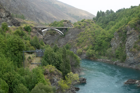 A beautiful view of the bridge across the turquoise river, consists of silt particles or glacial flour, which caused by glacier erosion at the top of mountain near the Kawarau Bridge, New Zealand.の写真素材