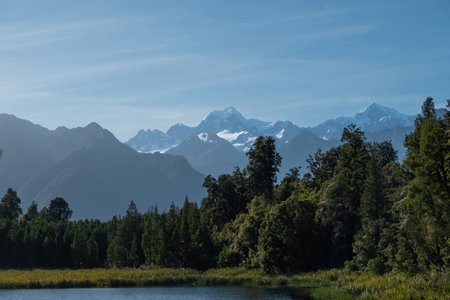 A viewpoint in Lake Matheson with beautiful Mount Cook and Mount Tasman peaks under the fresh blue sky morning background.の写真素材