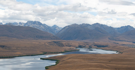 A beautiful breathtaking scene of a massive mountain range and peaceful lake from University of Canterbury Mt John Observatory, Mt John hill, Lake Tekapo, New Zealand.の写真素材