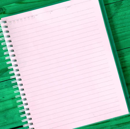 A blank notebook page on table wood office notebook Top view for design and background.の写真素材