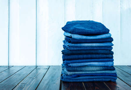 jeans stacked on a wooden backgroundの写真素材