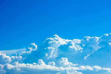 Sky background is vast with white clouds.