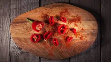 red hot chili pepper corns and pods on dark vintage metal culinary background