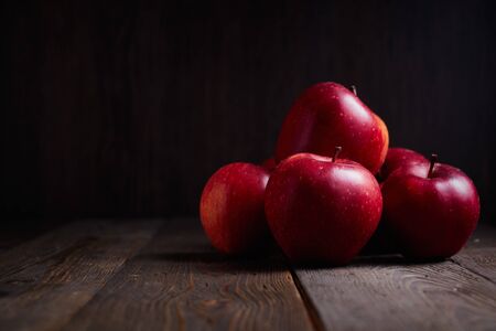 Red Braeburn Apples on rustic wood surface.