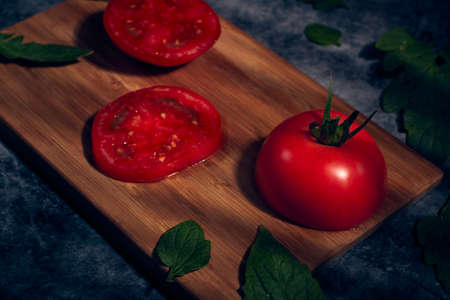 Slice of fresh plum tomatoes. Vegetable salad. Tomatoes on cutting board.の写真素材