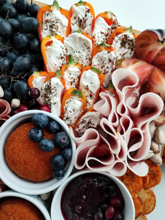 Slices of ham and cheese on a plate with fruits and vegetables