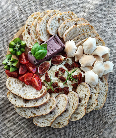 Charcuterie board, Delicious appetizer with cheese, olives, tomatoes and breadの写真素材