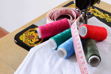 Close up image of sewing machine with colored threads and sartorial meter 