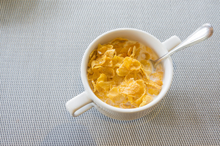 Cereal bowl and spoon with milk.