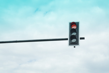 Red color on the traffic light with a white cloud in backgroundの写真素材