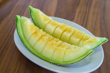 Cantaloupe melon slices on wooden table.の写真素材