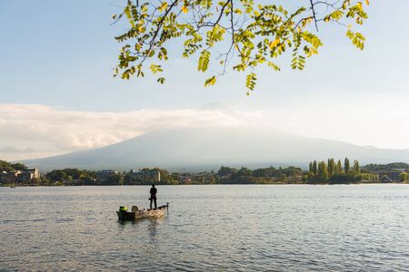FUJI-KAWAGUCHIKO, JAPAN - October 17 ,2014 : Mountain Fuji and lake kawaguchiko with fisherman on the boat
, Japan on october14 ,2015. Mountain Fuji and lake kawaguchiko.,snow-capped Mount Fuji with clear sky backgroundのeditorial素材