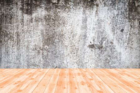 Wood table top on blurred background of vintage wall in industrial building with light from corner の写真素材