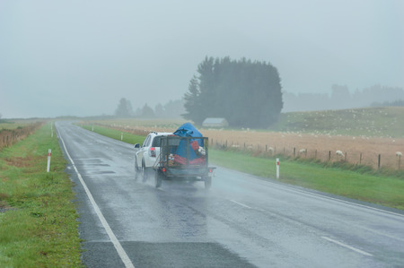 QUEENSTOWN, NEW ZEALAND - November 1: 
Tourists driving in New Zealand country road on a rainy day
on November 1, 2014 in Queenstown, New Zealand.のeditorial素材