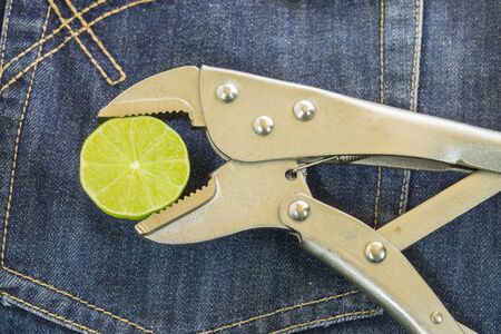 locking Pliers and lime put on jeans background.の写真素材