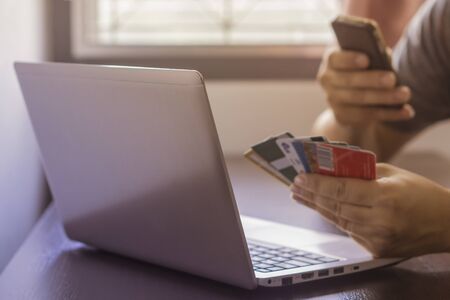 Close Up Of A Man Shopping Online Using Laptop With Credit Card,male hands holding credit card...