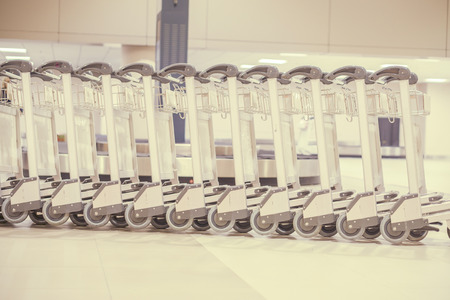 luggage carts at modern airport,trolleys luggage in a row in airport, retro filter effect,selective focusの写真素材