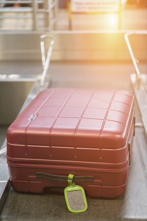 Baggage claim  suitcases on a luggage band on the  on conveyor belt at the airport - selective focus,vintage colorの素材 [FY31062834624]