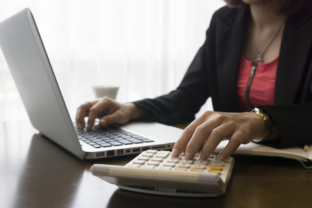 Finance & Business, women Analysis Business Accounting,hands typing keyboard and pressing calculator buttons over documents,financial manager taking notes in office,selective focus,vintage tone Finance & Business, women Analysis Business Accounting,hands typing keyboard and pressing calculator buttons over documents,financial manager taking notes in office,selective focus,vintage tone