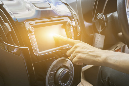 Transportation,technology and vehicle concept - man using car system control pushing panel button screen interface modern designの写真素材