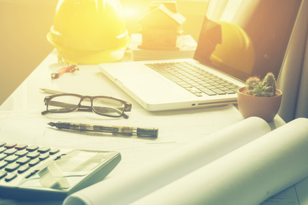 Architect working,repair, building and home concept,making changes to a blueprint,laptop pc for designer drawing house plan for reconstruction. Architectural project ,selective focus,vintage colorの写真素材