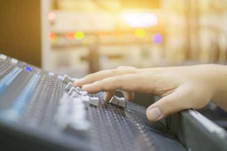 studio working with sound and light mixer console,hands of sound engineer working on recording studio mixer,Expert adjusting the volume of a sound mixer audio mixing console with mixer board,vintageの写真素材