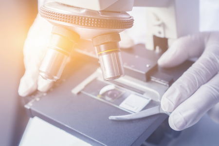 medical laboratory, scientist hands using microscope for chemistry test samples,examining samples and liquid,Medical equipment. microscope,Scientific and healthcare research background.vintage colorの写真素材