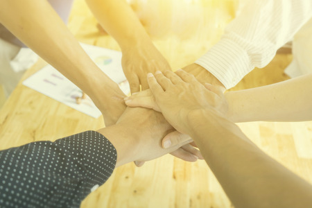 Teamwork concept,Business team standing hands together in the loft office.people joining hands for cooperation success business,win in every thing,vintage colorの写真素材