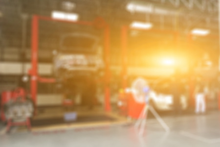 Blurred of car technician repairing the car in garage background, Interior of a car repair station.vintage colorの写真素材