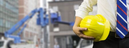 engineer or worker hold in hand yellow helmet  discussing blueprint next to electrical substation...