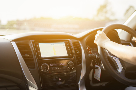 Hands on the steering wheel ,Car driving with both hands on the wheel,Female driving car inside car with modern dvd,radio,gps. Vintage filter,selective focusの写真素材