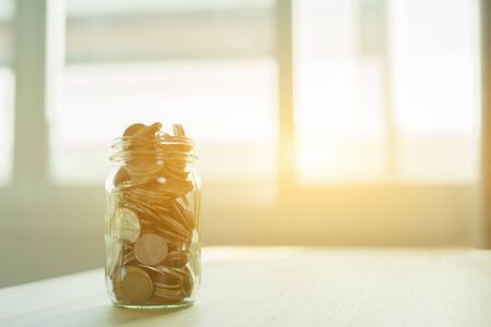 Money and banking concept with coins and jar. glass Jar for savings full of coins.Glass jar with...