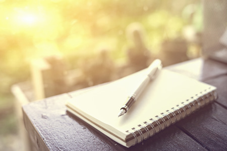 pen  on the desk,Open a blank white notebook,vintage color,selective focusの写真素材