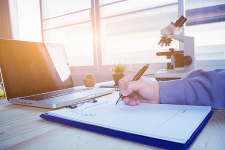 male doctor,surgeon,nurse,pharmacy with stethoscope on hospital holding clipboard,writing a prescription,Medical Exam,Healthcare and medical concept,test results,vintage color,selective focusの写真素材