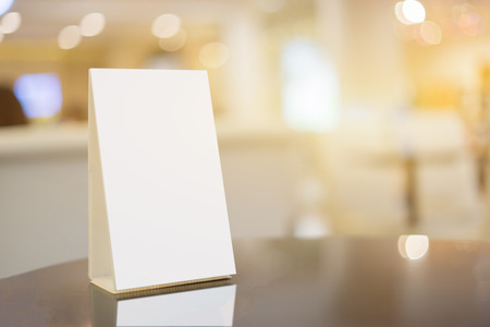 Mock up Menu frame on Table in Bar restaurant cafe,Stand for booklets with white sheets of paper acrylic table tent card mockup on wooden table on cafe teria blurred backgroundの写真素材