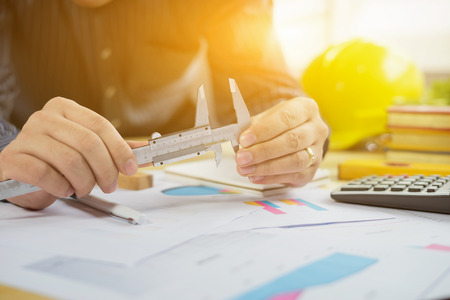 architect work concept.man working with new startup project in modern loft. Drawning pen,inspection engineer report with product and vernier calipers,engineer architectural project,Notebook on tableの素材 [FY31066427566]