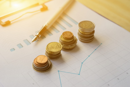 Saving coins money concept,money coins graph, money stacks of coins ,coins money chart and pen ,copy space.selective focus,vintage colorの写真素材