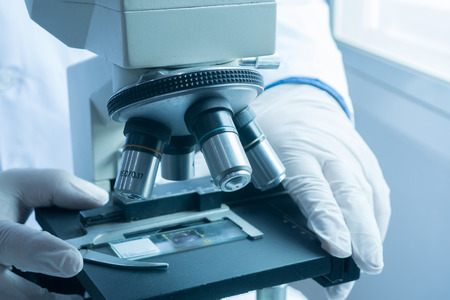 medical laboratory, scientist hands using microscope for chemistry test samples,examining samples and liquid,Medical equipment. microscope,Scientific and healthcare research background.vintage colorの写真素材