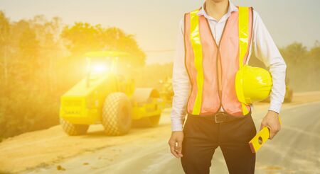 engineering management construction concept,engineer holding  hand a  yellow helmet and measure equipment security,Architects overseers on working site background ,for banner  websiteの写真素材
