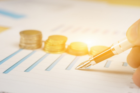 Finances statement with Pen,hand pointing business charts,coins on paper work in the...