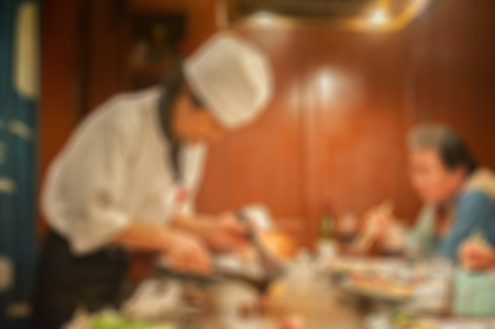 Blurred background : Group of chefs cooking in the kitchen,Grilling beef steak (japan kobe matsusaka),japanese style lobster, tepan yaki,Restaurant chef: customer can see they are cook ,vintage colorの写真素材