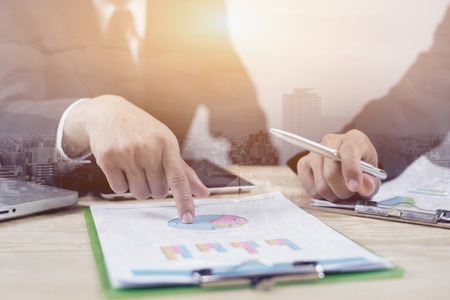 Teamwork concept,operate  with collaborative cooperation or participation,Businessman team analyzing income charts and graphs in office .Business analysis and strategy concept.double exposureの写真素材
