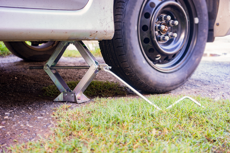 Car Lifted With Hydraulic Floor Jack For tire Repairing ,Replacing wheels on a car, jacks holds the body in raised positionの写真素材