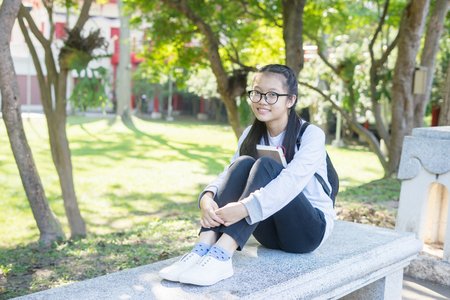 Adorable girl in summer garden park reading book ,vintage colorの写真素材