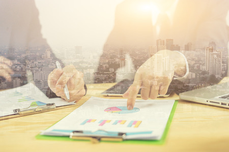 Businessman making presentation with his colleagues and business strategy,pointing and write goals on a paper,writing business plan at workplace,discussing financial diagram, graph, business conceptの写真素材