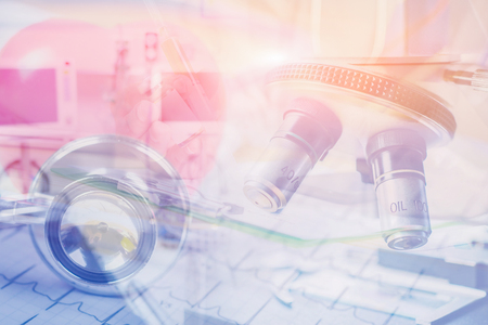 double exposure medical laboratory,scientist hands using microscope for chemistry test samples,Stethoscope,heart cardiogram on clipboard pad Cardio therapeutist assistance Scientific and healthcareの写真素材