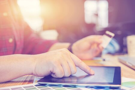 Online payment,Businessman hand holding entering information from a credit card using tablet,...